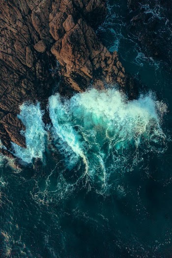 High Angle View of a Wave Splashing Against a Cliff
