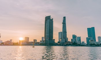 High-rise Buildings Near Sea Taken Under White Clouds
