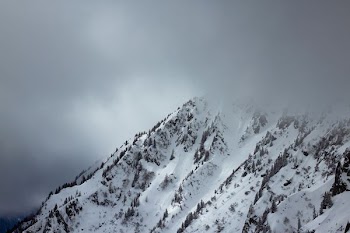 hills covered with snow over nimbus clouds