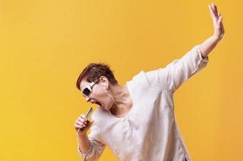 Hipster senior woman singing and listening music Free Photo