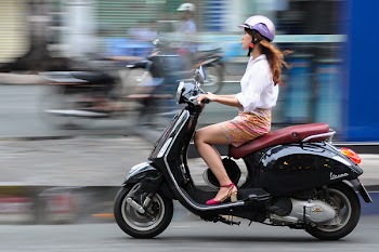 Ho Chi Minh, Vietnam. June 12, 2014 : A lady ride a scooter in Ho Chi Minh City Vietnam. According to report in 2016 there is more than 7.4 million motorcycle in Ho Chi Minh City.