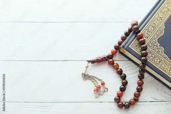 Holy book Quran and muslim rosary on table with copy space 