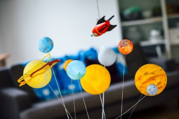 Homemade planetarium and rocket hanging above in a living room. Close...
