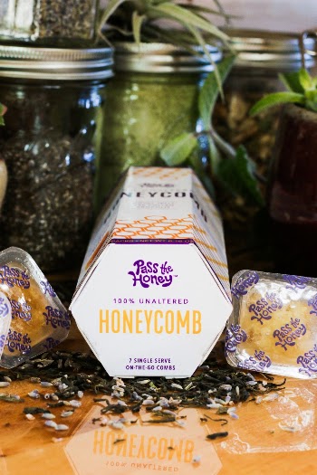 Honeycomb product on the kitchen counter with a variety of herbs and spices in jars. 