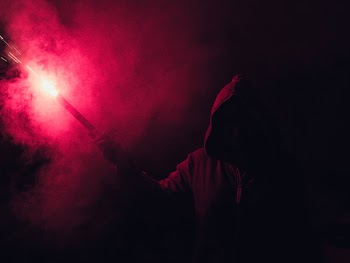 Hooded Figure Holding Red Flare