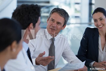 Hospital administrator talking with doctors in meeting