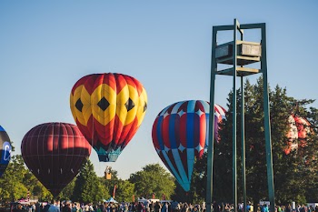 Hot Air Balloons On Field Surrounded By People