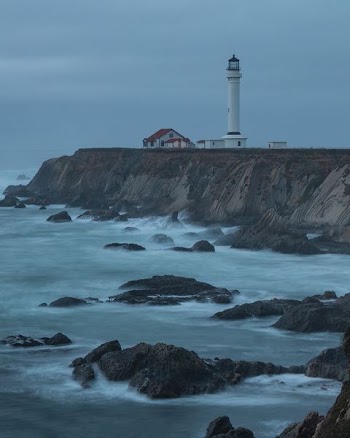 house beside lighthouse near body of water