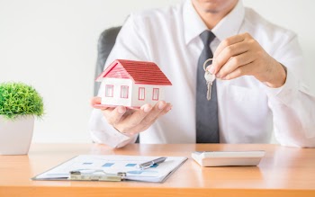 House key in home insurance broker agent's hand protection Free Photo