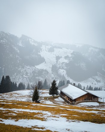 House Near Mountain Covered With Snow