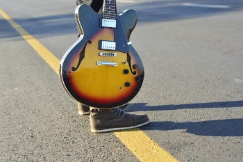 Human Holding a Brown and Black Electric Guitar during Daytime