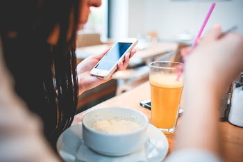 Human Holding Iphone Infront on White Round Bowl