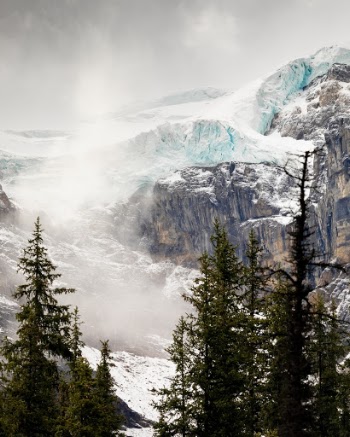 I recently went on a 10 day holiday to Banff, Canada. Banff is somewhere that I've wanted to go for about 15 years and it was even better than I expected. I took this photo at the back of Moraine Lake. I went there to get the good photos everyone would expect, but I also wanted to capture shots not everyone thinks about. I made an effort to "Look behind where you're standing" in order to capture something a little different. In this shot, you can see some of the blue glacial ice above the Moraines that surround the Lake and the extremely dynamic weather that you get in the Canadian Rockies.
