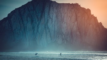 I visited Morro Rock at December, 2018. It was little cold that time and the sun went down behind the rock. The cold air from inland casted a blue color and the sun filled with golden color. Some kids played surfing on beach brought more vibrant into the scene. 