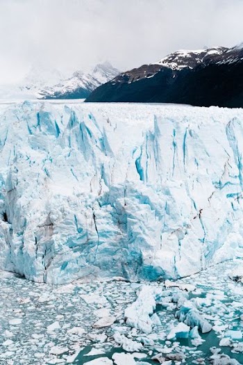 iceberg near mountain at daytime