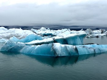 iceberg under cloudy sky