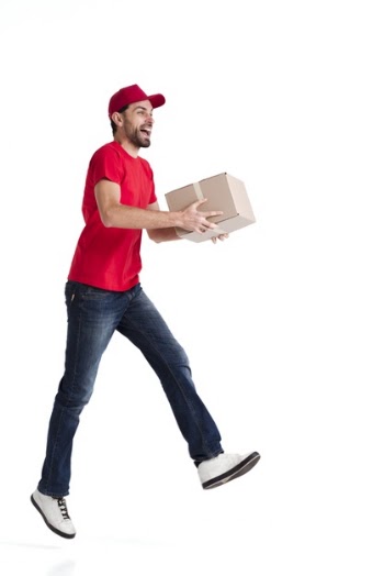 Image of a young delivery man walking sideways with a box Free Photo