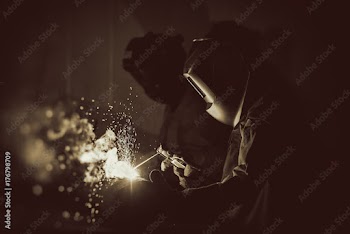 Industrial Worker at the factory welding close up .