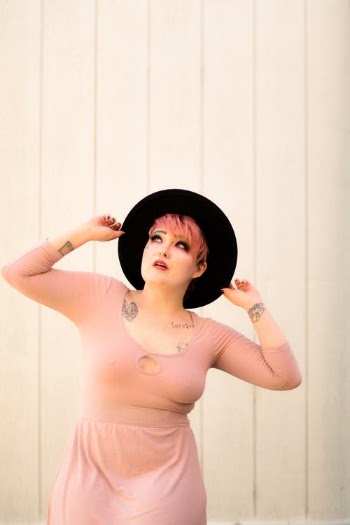Informal woman with hands on hat · Free Stock Photo