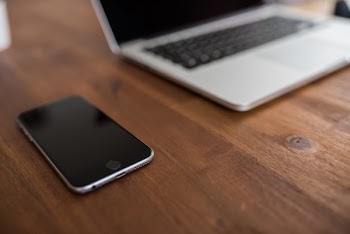 iPhone &amp; Macbook Computer on Wood Desk