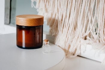 Jar of cream and bottle of perfume placed on table
