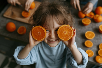Joyful Child with Oranges in Cozy Kitchen