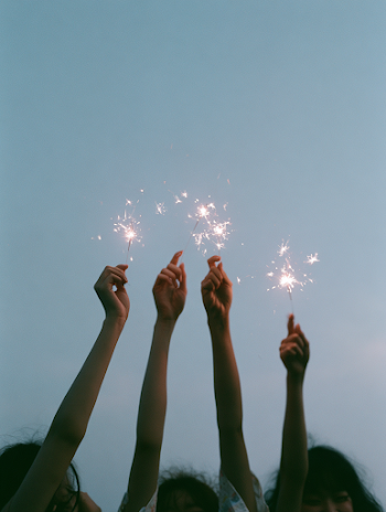 Joyful Hands Raising Sparklers at Dusk