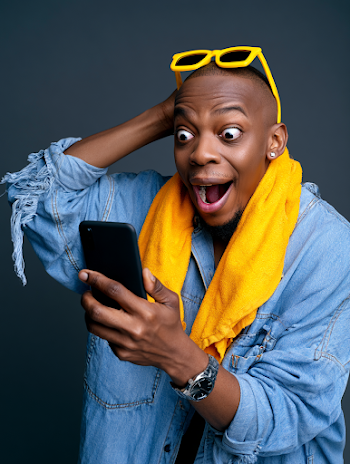 Joyful Young Man with Smartphone in Studio