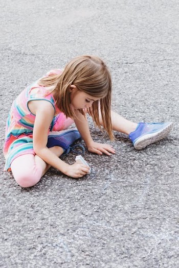 Kid Draws On Ground With Chalk