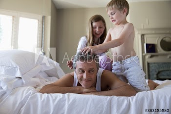 Kids playing with father on bed