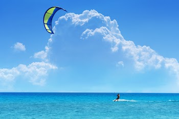 Kiteboarder with blue - yellow kite