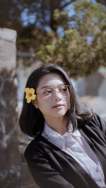 Lady Wearing Eyeglasses With Yellow Bell Flower On Hair