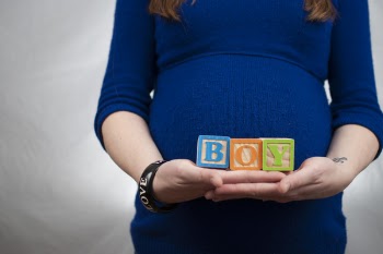 Lady Wearing Lbue Long Sleeve Dress and Holding Boy Piece Box