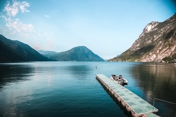 Lake Surrounded by Mountains Under Blue Sky