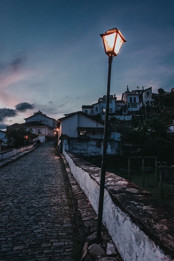 Lamppost on Concrete Bridge Near Buildings during Day