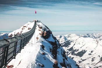 landscape photo of flag on mountain covered with snow