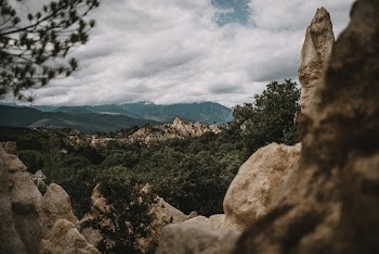 Landscape Photo of Mountains and Trees Under Cloudy Sky