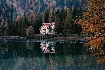 landscape photo of white and red house near lake