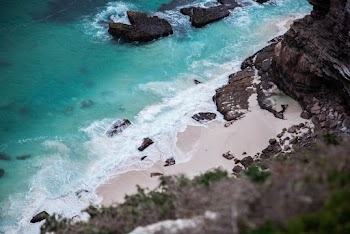 Landscape Photography of Black Rock Formations Near Body of Water