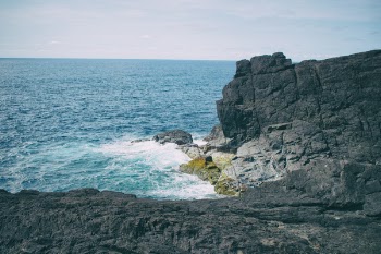 Landscape Photography of Boulder Near Body of Water