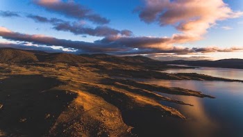 landscape photography of brown mountains near body of water