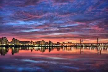 Landscape Photography of City Near Suspension Bridge Near Body of Water during Golden Hour