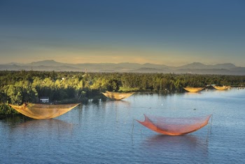 Landscape Photography of Fish Nets on Body of Water Near Green Trees