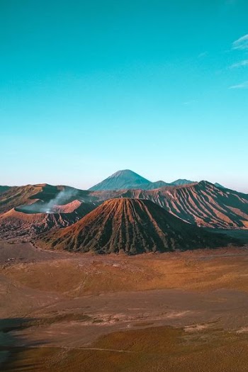 landscape photography of hill under blue sky