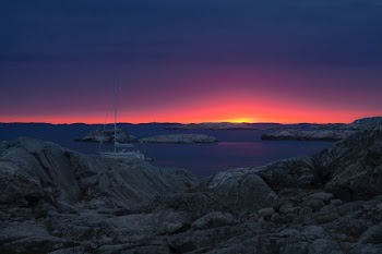 landscape photography of sailing yacht against golden sun