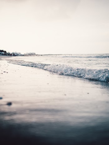 Landscape Photography of Seashore With Calm Sea Waves Under Gray Skies