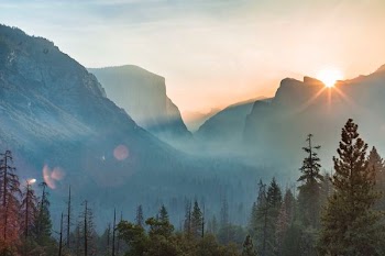 landscape photography of sun peeping on mountain range