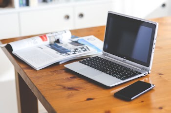 Laptop &amp; cell phone on a wooden desk