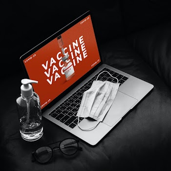 Laptop screen showing COVID-19 vaccine vial ads
