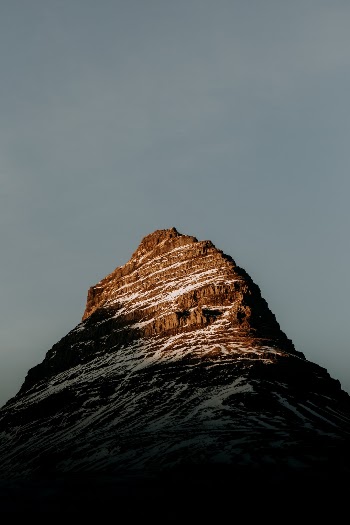 Last light hitting a snowy Kirkjufell Mountain at sunset in Iceland.